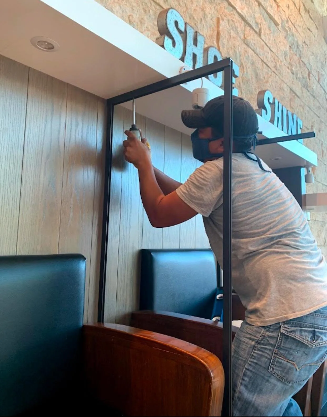 Technician fitting a framed glass partition in a commercial space