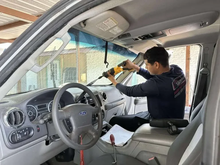 USA GLASS technician removing a windshield from inside a Ford vehicle
